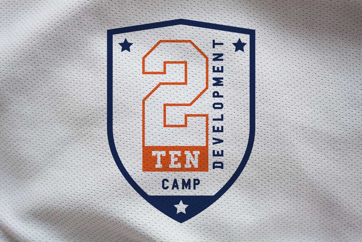 2Ten Camp Identity - 2 Ten Development Camp logo on a textured fabric background featuring a shield design with a bold number 2, orange and navy blue accents, and stars for decorative elements.