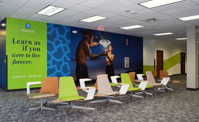 Pearson – Austin - Pearson learning space featuring inspirational quote ‘Learn as if you were to live forever,’ modern seating, and vibrant wall design.