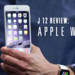 Close-up of a person holding an iPhone, wearing an Apple Watch, with text overlay ‘J 12 Review: Apple Watch