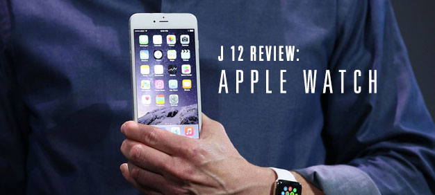 Close-up of a person holding an iPhone, wearing an Apple Watch, with text overlay ‘J 12 Review: Apple Watch