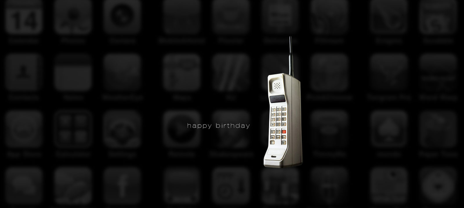 Retro mobile phone on a dark app icon background with the words ‘Happy Birthday’ displayed, celebrating technology evolution.