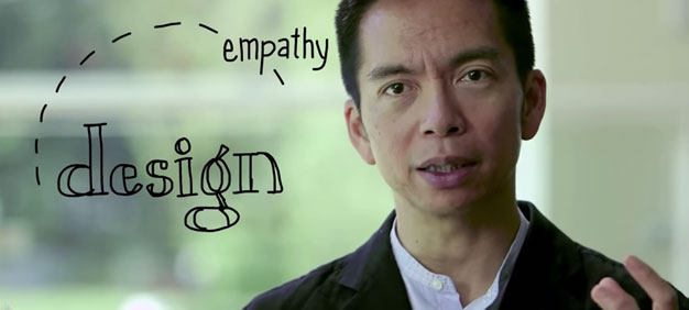 Close-up of a person speaking, with the words ‘empathy’ and ‘design’ handwritten in a creative style overlaying the background