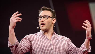 Speaker passionately addressing an audience during a presentation, wearing a checkered shirt and a microphone headset