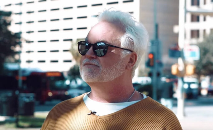 a man wearing sunglasses and a yellow sweater