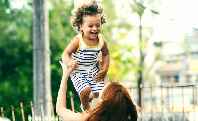 a woman holding a baby up in the air