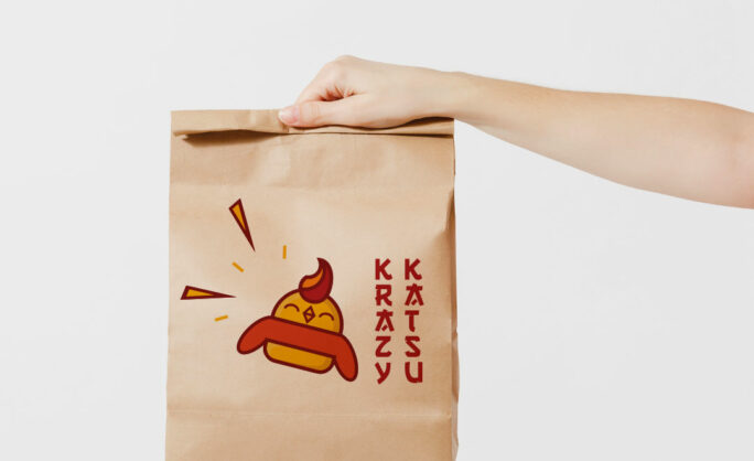 a hand holding a brown paper bag