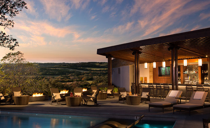 a pool with chairs and tables around it