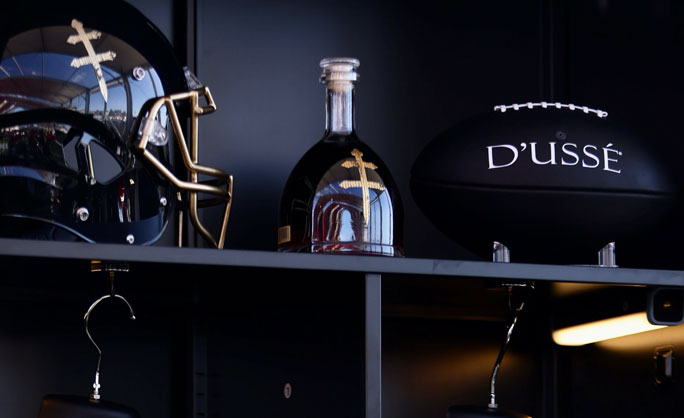 a football helmet and a bottle of liquor on a shelf