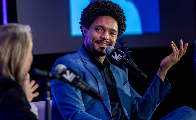 Trevor Noah, a man in a blue suit speaking into a microphone